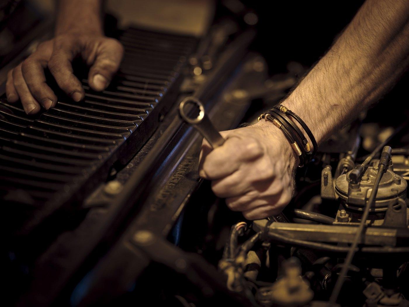 Hands tightening a bolt with a wrench
