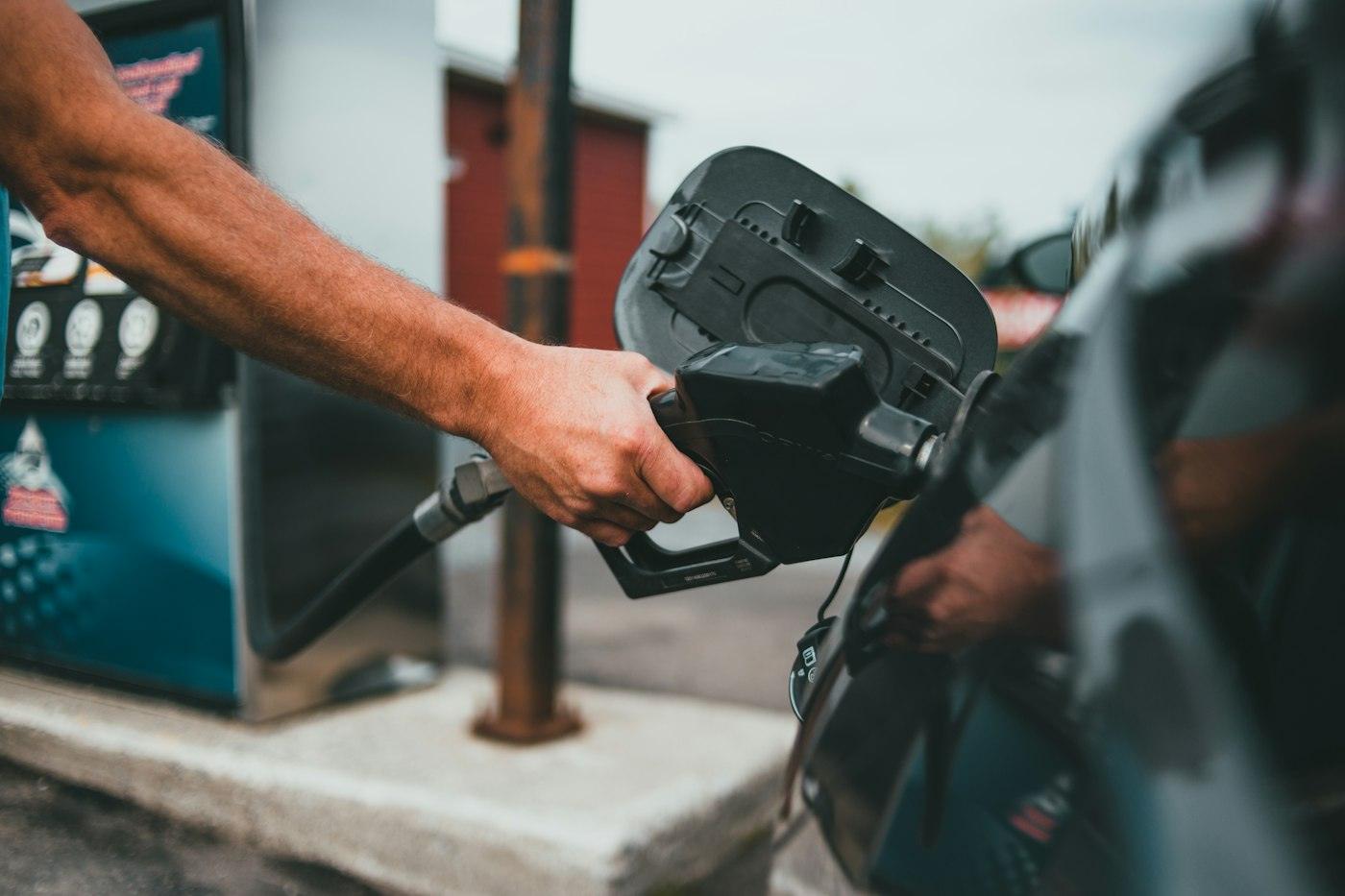 Driver refuelling a car at a petrol pump