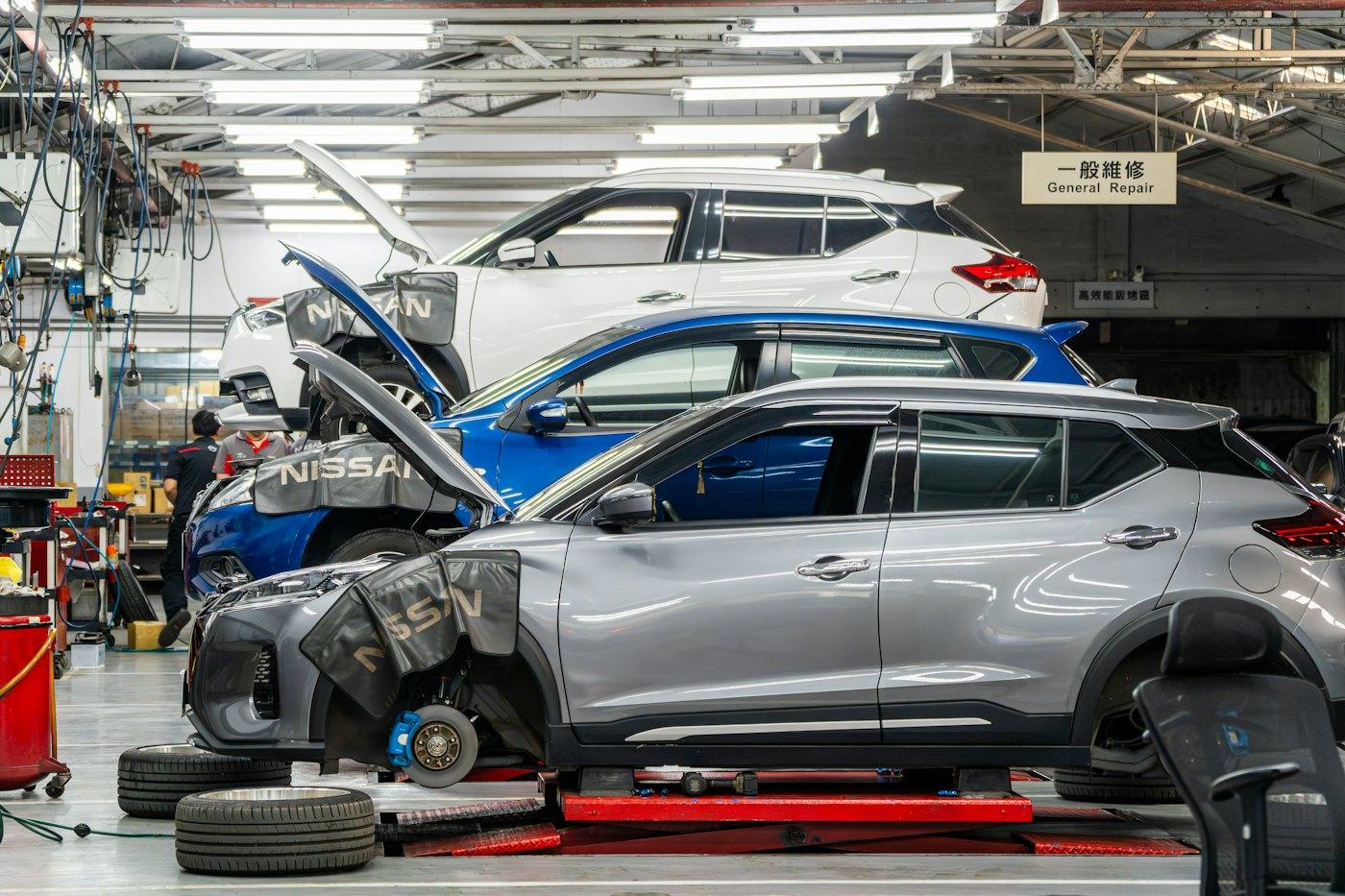 Several cars being repaired in a bright workshop