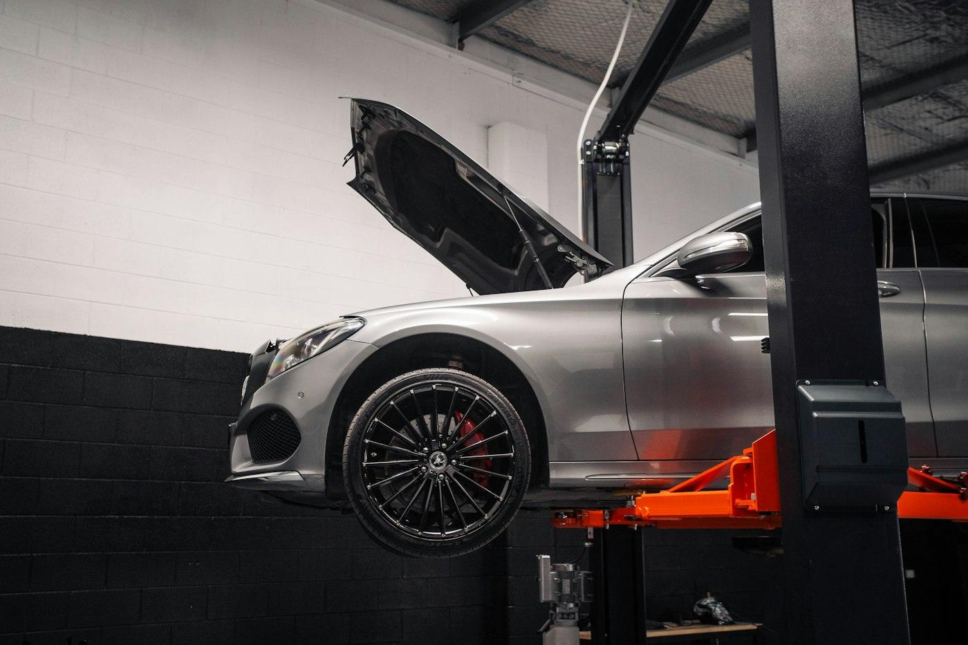 Silver car raised on a hydraulic lift