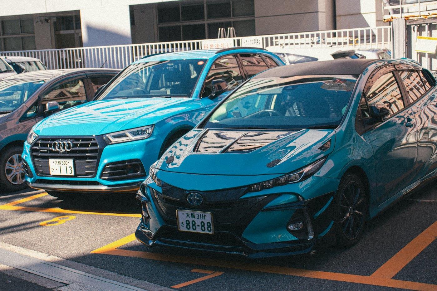 Teal Toyota Prius hybrid parked in a city car park